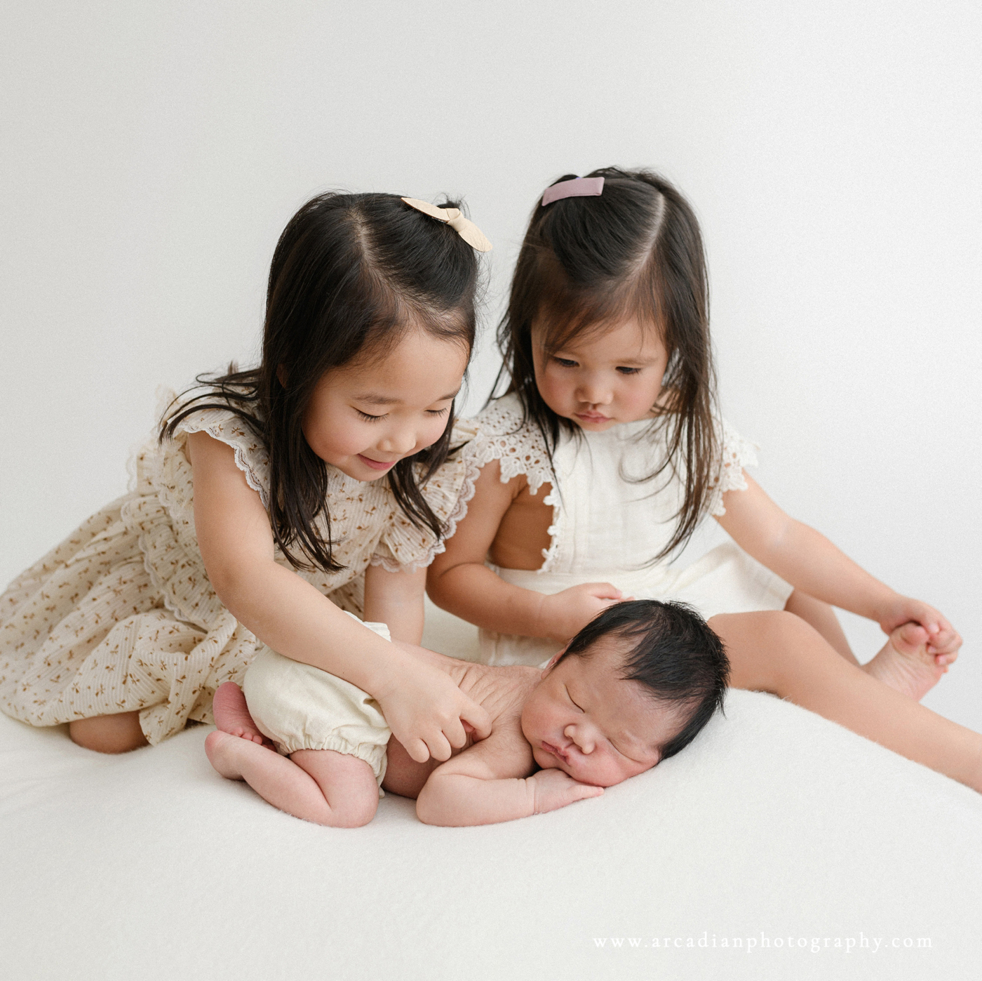 older sisters tickling newborn baby brother at newborn session - Arcadian Photography