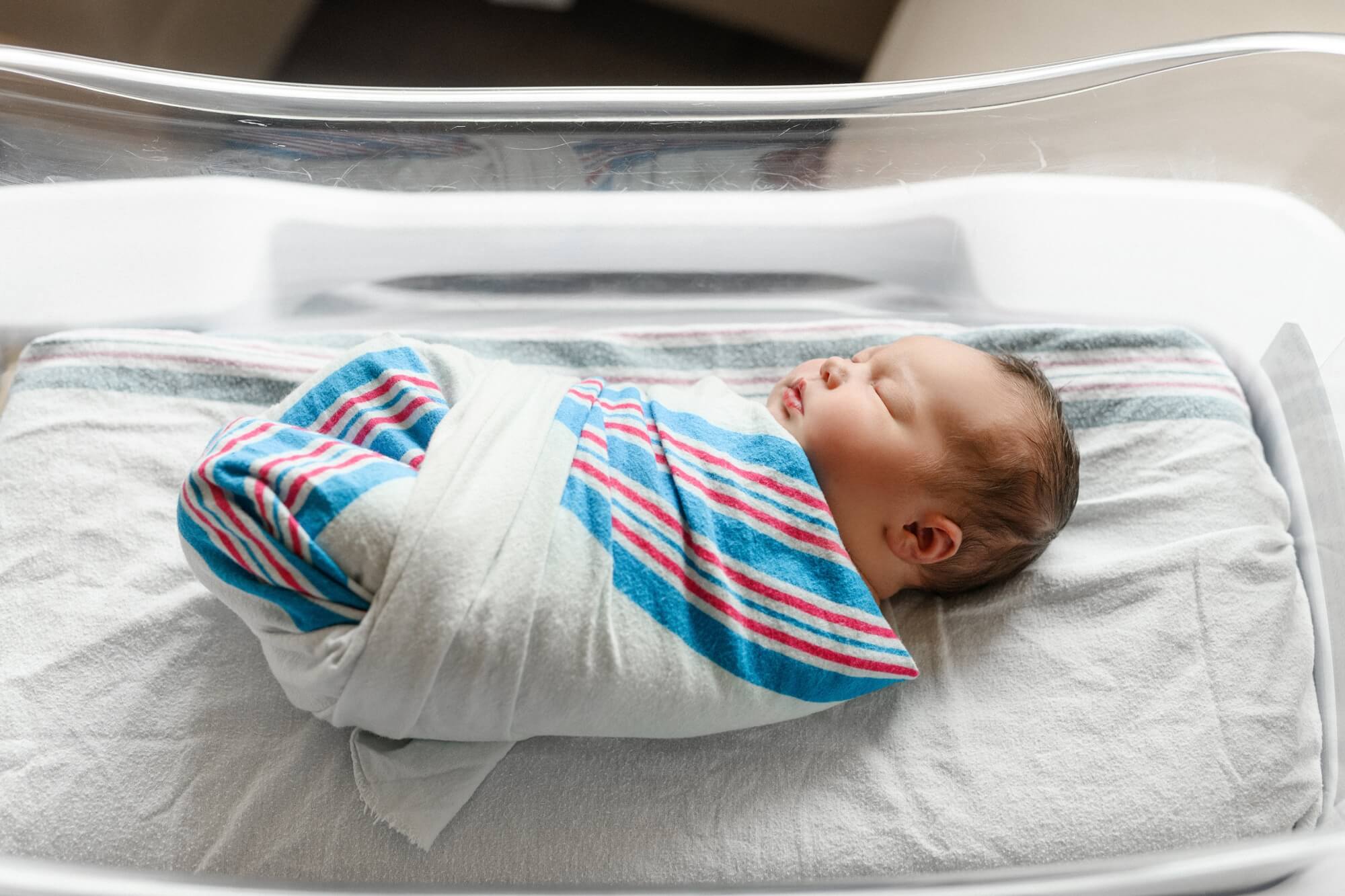 newborn baby in hospital bassinet