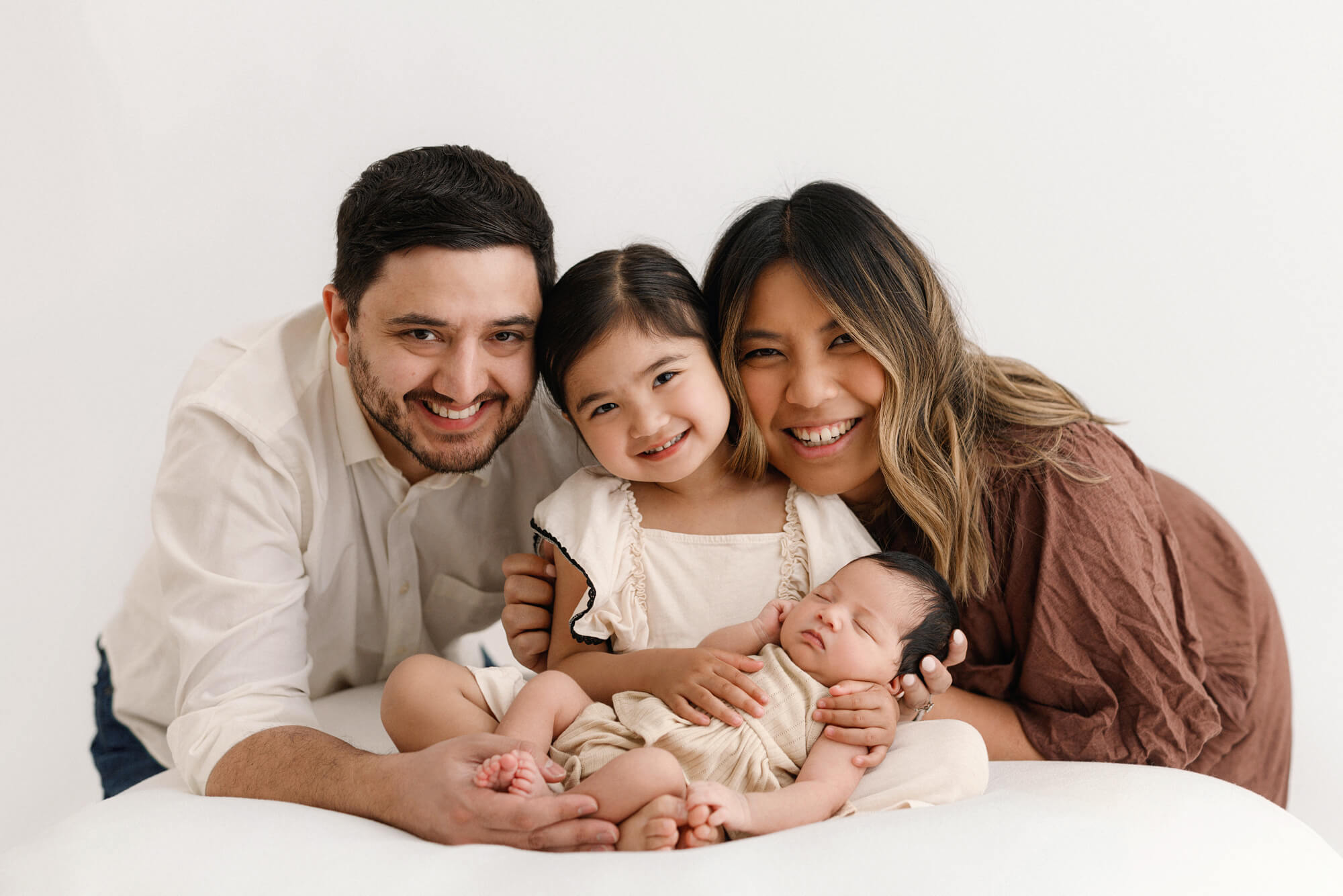 family takes newborn photos with a toddler