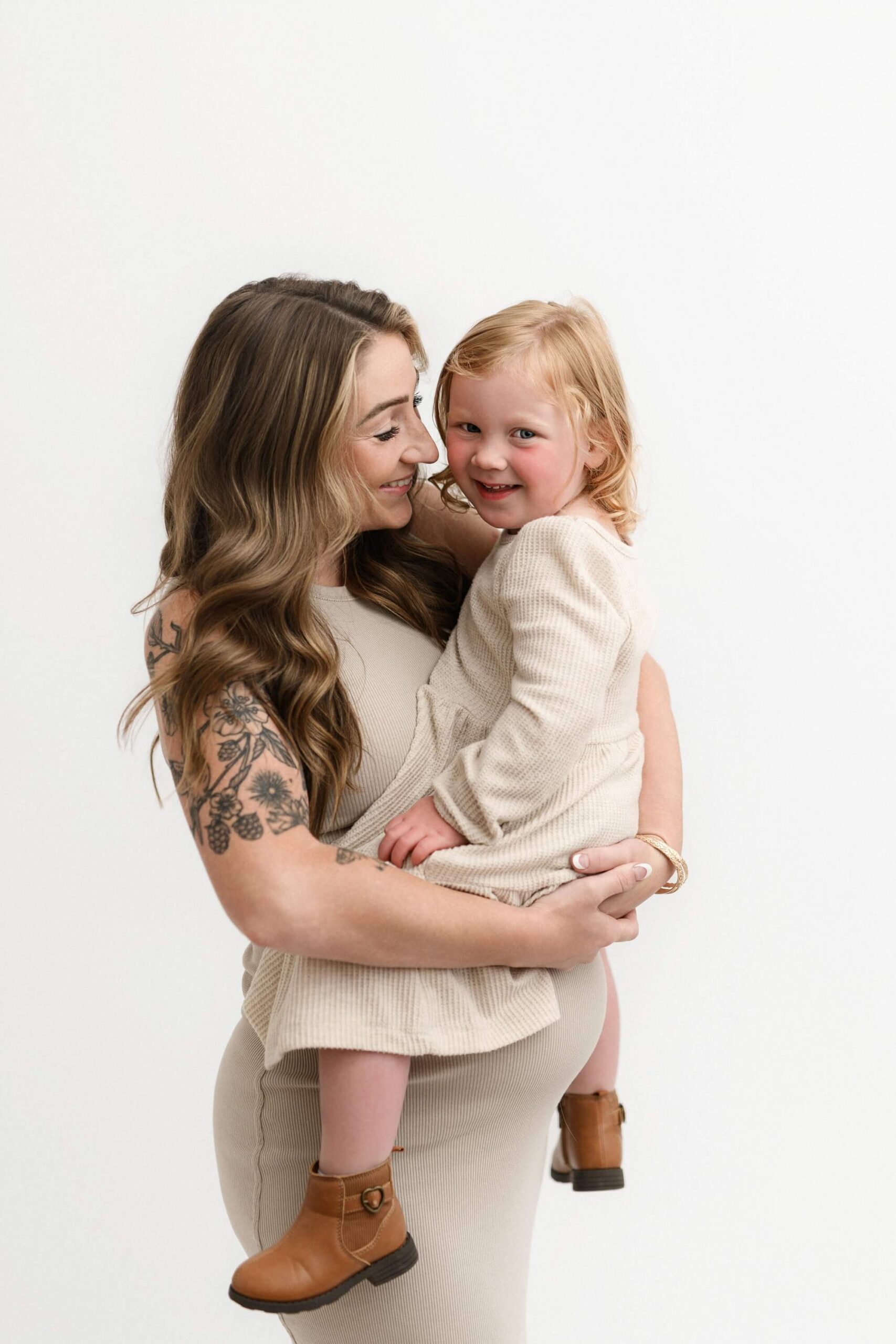 Pregnant mother holding her laughing toddler close during maternity photos with partner and siblings in Portland, Oregon.