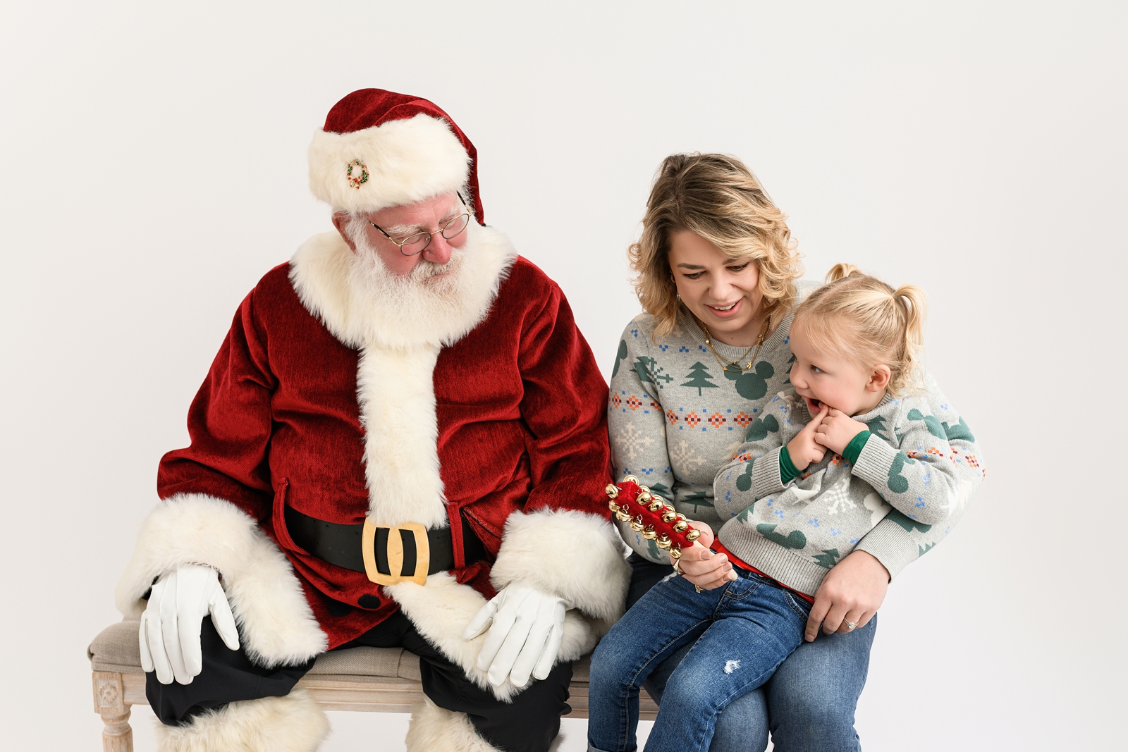 Parent comforting a nervous toddler while meeting Santa