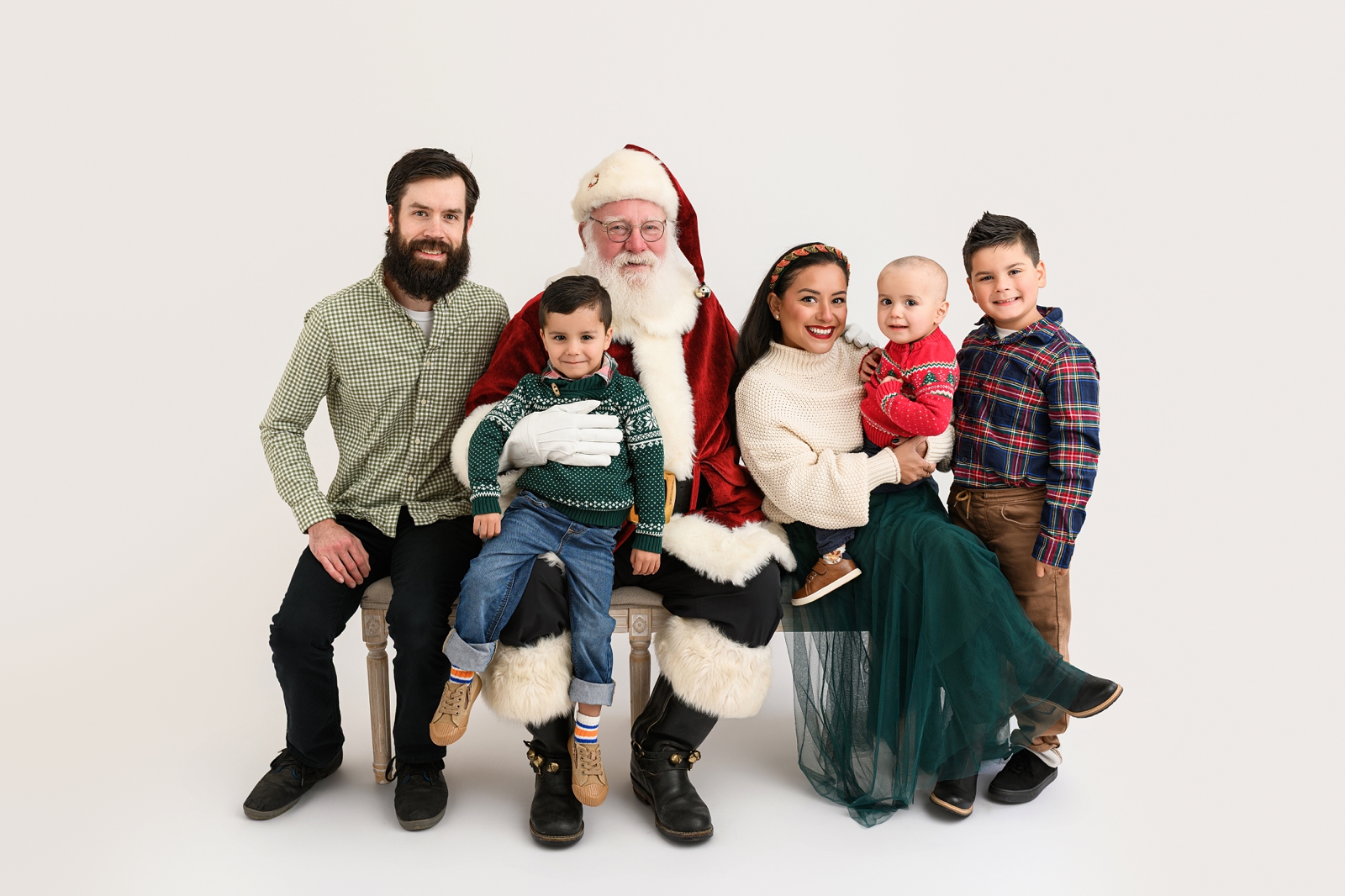 Family wearing coordinating Christmas outfits for a Santa photo session.